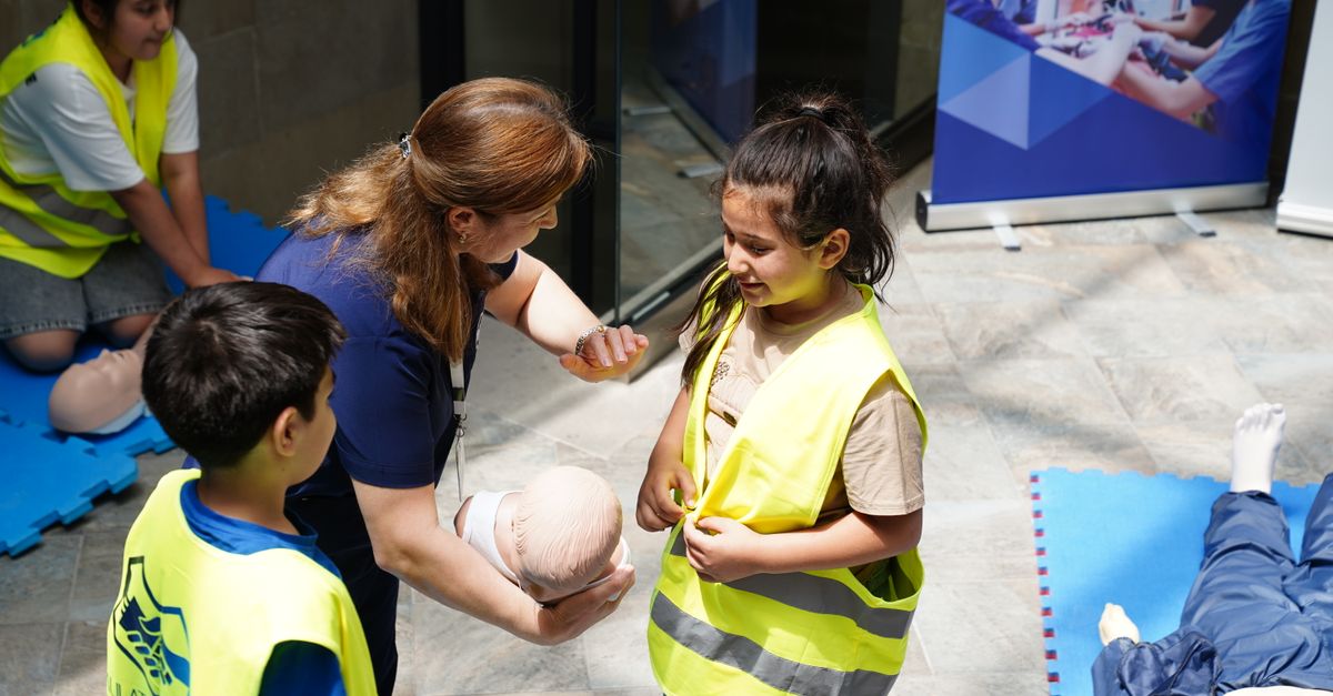 Kids and instructor learning CPR techniques during first aid safety training.